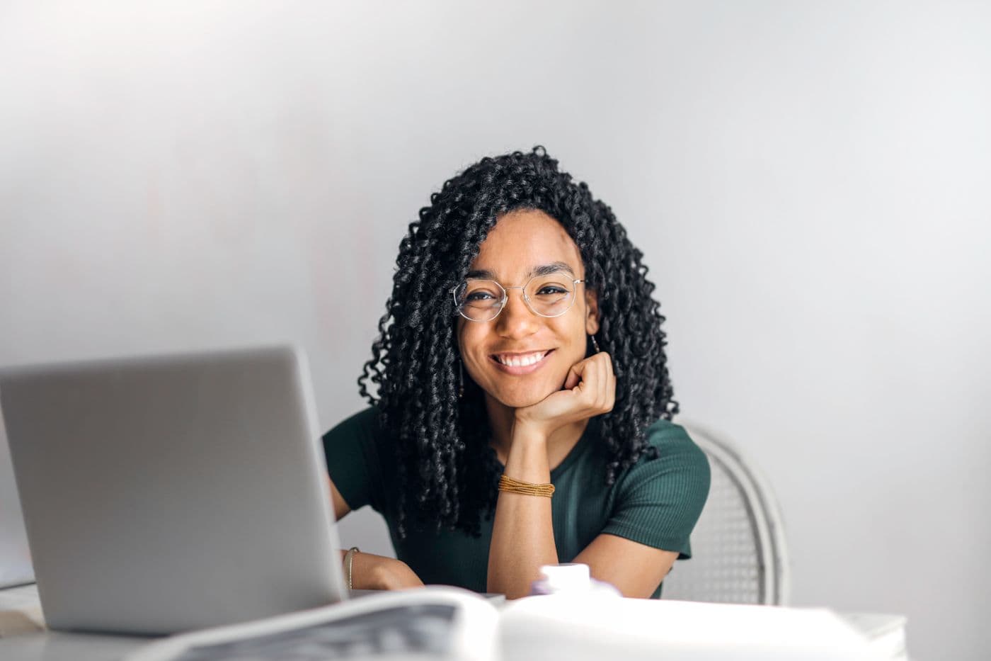 A creator at a laptop, smiling toward the camera